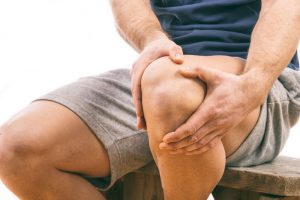 man holding his knee in pain