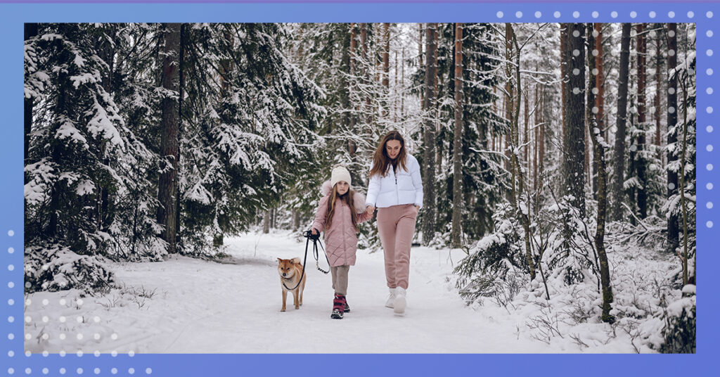 mom and daughter walking their dog during winter